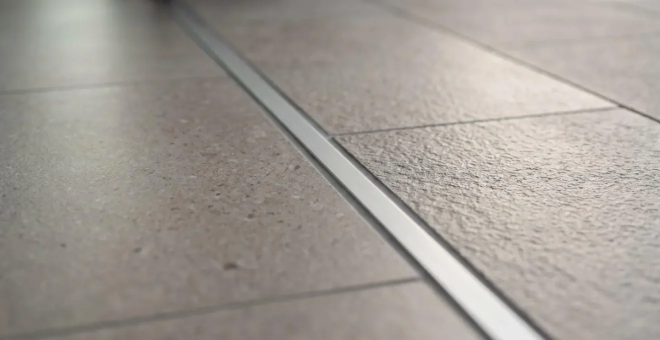 Vue détaillée d'un carrelage continu traversant un seuil encastré entre intérieur et terrasse
